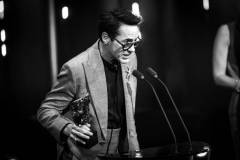LONDON, ENGLAND - FEBRUARY 18: (EDITORS NOTE: Image has been converted to black and white.) Robert Downey Jr. accepts the Supporting Actor Award for 'Oppenheimer' on stage during the EE BAFTA Film Awards 2024 at The Royal Festival Hall on February 18, 2024 in London, England. (Photo by Joe Maher/BAFTA/Getty Images for BAFTA)