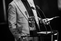 LONDON, ENGLAND - FEBRUARY 18: (EDITORS NOTE: Image has been converted to black and white.) Robert Downey Jr. accepts the Supporting Actor Award for 'Oppenheimer' on stage during the EE BAFTA Film Awards 2024 at The Royal Festival Hall on February 18, 2024 in London, England. (Photo by Joe Maher/BAFTA/Getty Images for BAFTA)