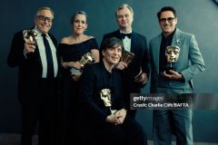 LONDON, ENGLAND - FEBRUARY 18:  (L-R) Charles Roven, Emma Thomas, Cillian Murphy, Christopher Nolan and Robert Downey Jr. are photographed backstage with their awards for the film Oppenheimer at the 2024 EE BAFTA Film Awards, held at The Royal Festival Hall on February 18, 2024 in London, England. (Photo by Charlie Clift/BAFTA/Contour by Getty Images)