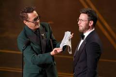 HOLLYWOOD, CALIFORNIA - MARCH 15: (L-R) Robert Downey Jr. and Chris Evans speak onstage during the 98th Oscars at Dolby Theatre on March 15, 2026 in Hollywood, California. (Photo by Kevin Winter/Getty Images)