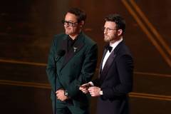 HOLLYWOOD, CALIFORNIA - MARCH 15: (L-R) Robert Downey Jr. and Chris Evans speak onstage during the 98th Oscars at Dolby Theatre on March 15, 2026 in Hollywood, California. (Photo by Kevin Winter/Getty Images)