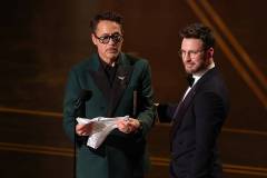 HOLLYWOOD, CALIFORNIA - MARCH 15: (L-R) Robert Downey Jr. and Chris Evans speak onstage during the 98th Oscars at Dolby Theatre on March 15, 2026 in Hollywood, California. (Photo by Kevin Winter/Getty Images)